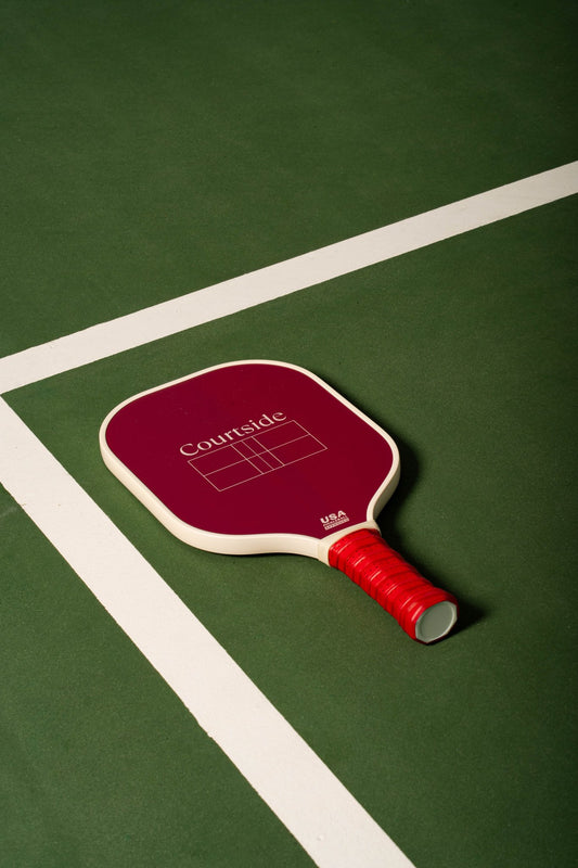 beige pickleball paddle with mahjong tiles in a red accent
