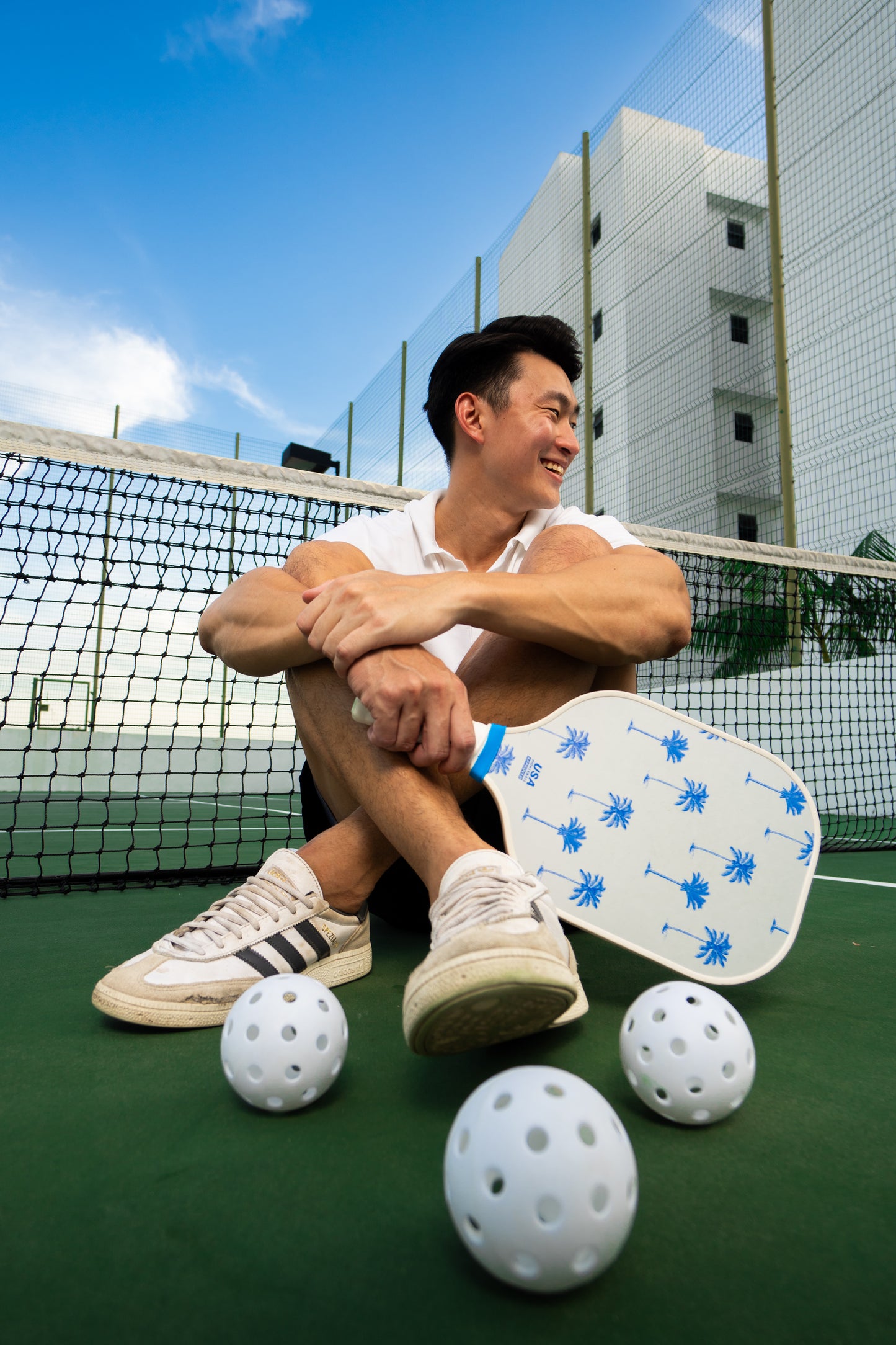 white pickleball paddle with blue palm trees