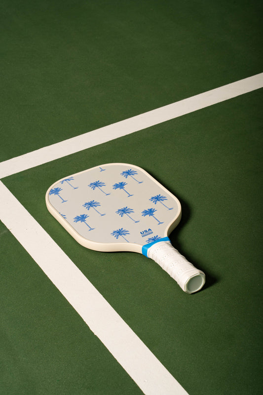 white pickleball paddle with blue palm trees