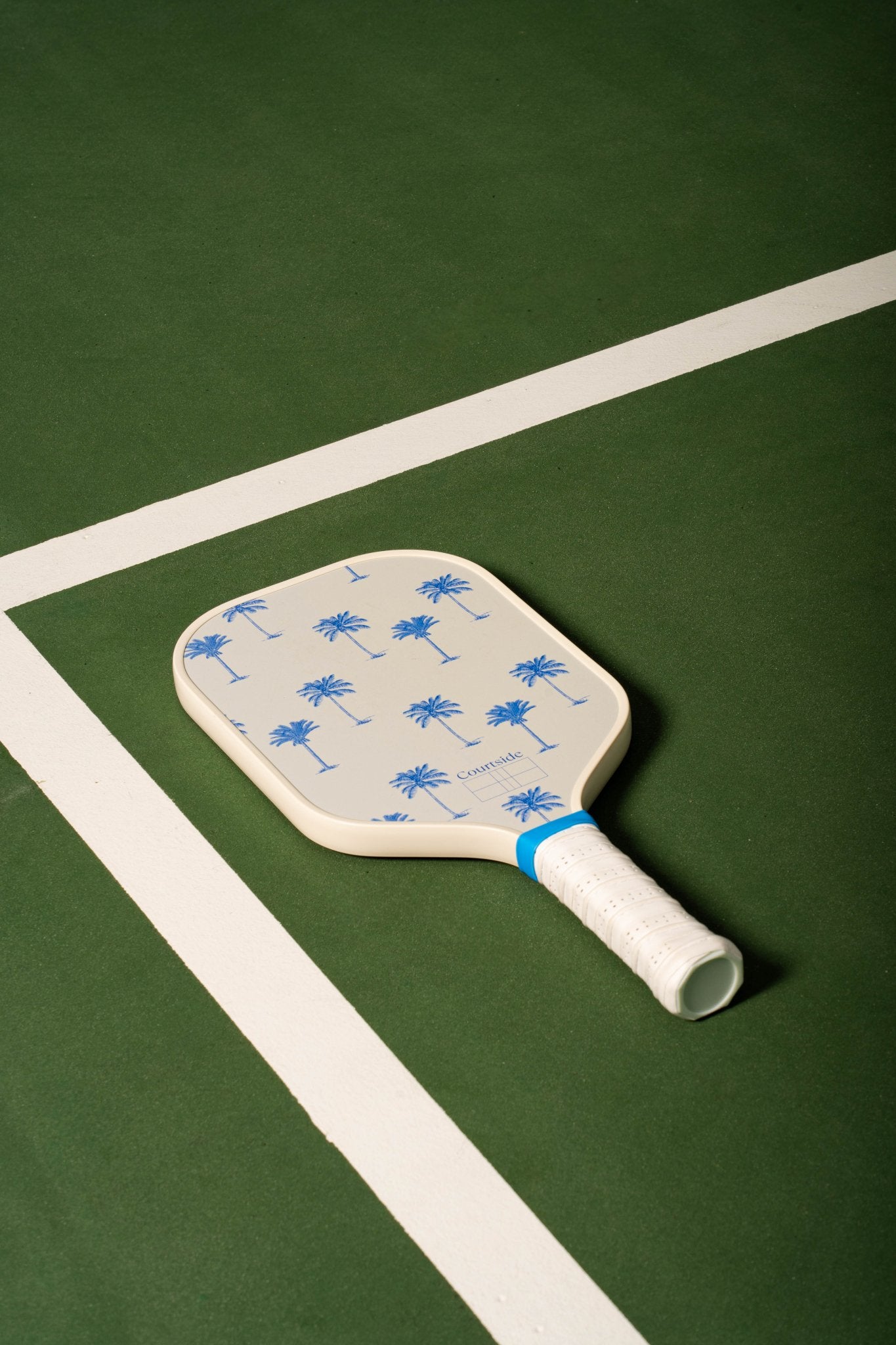 white pickleball paddle with blue palm trees