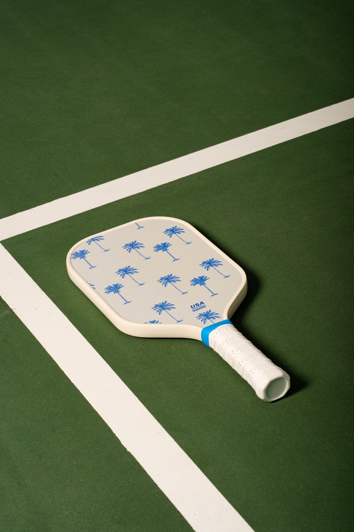 white pickleball paddle with blue palm trees